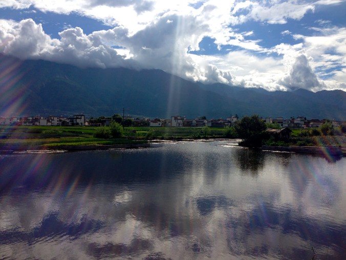 Clouds are reflected in a small pond outside Dali. 